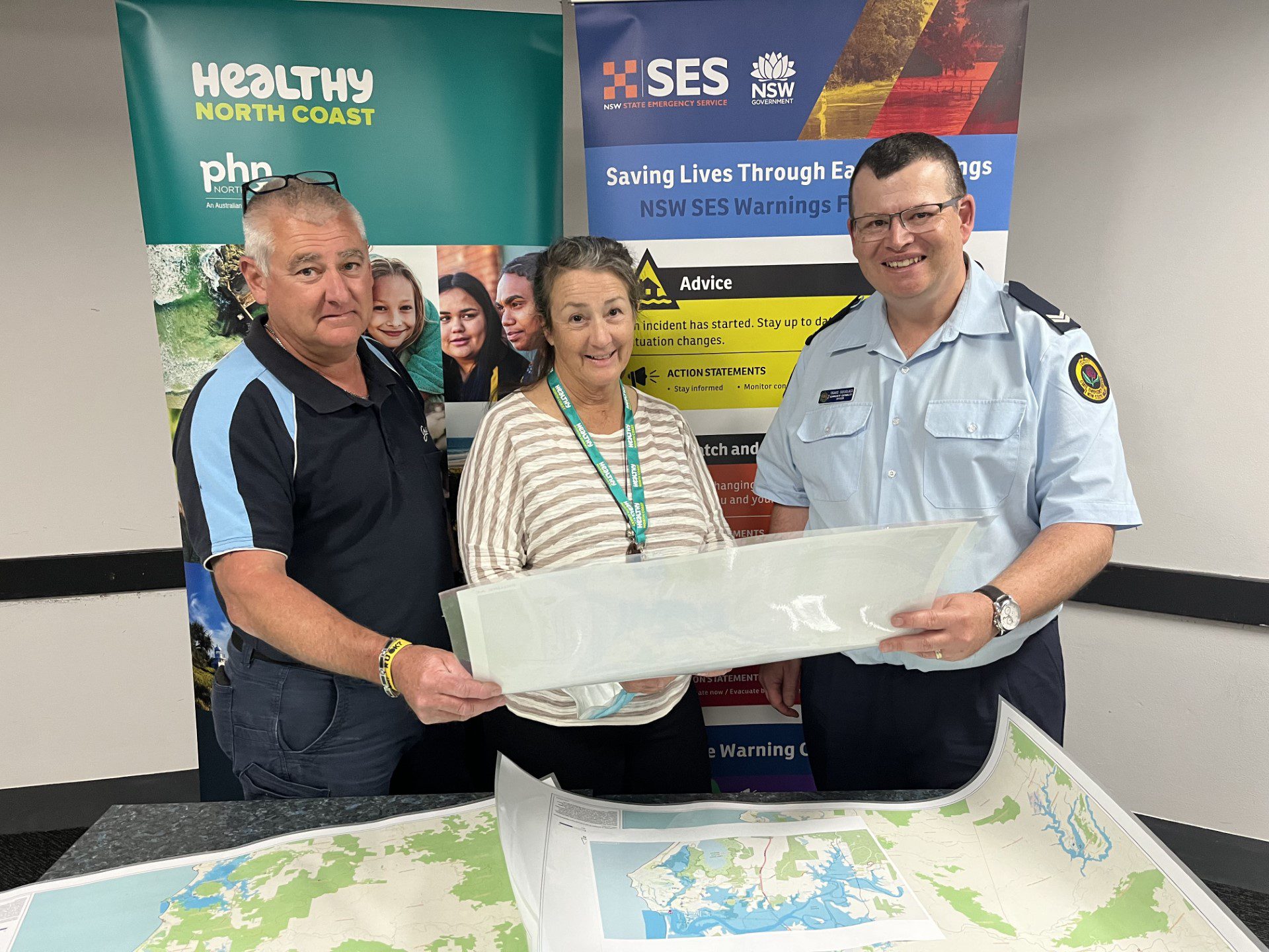 An image of Special Emergency Services (SES) officers with a member of Healthy North Coast meeting about how to prepare aged care homes for disasters